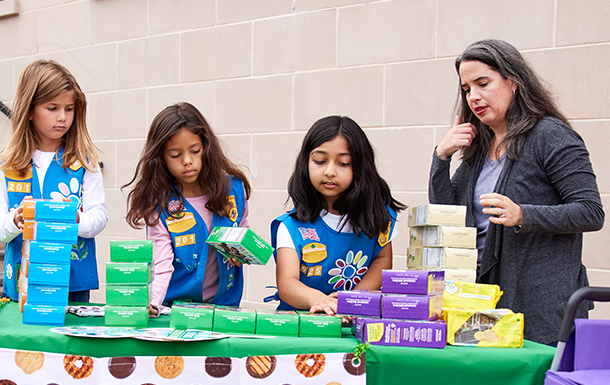 girl scout selling cookies with parent