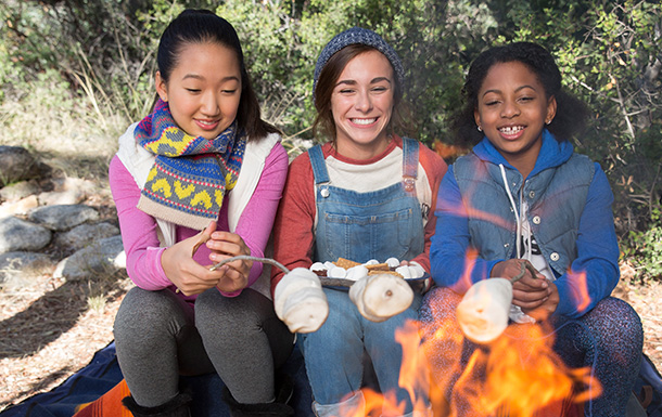 girls roasting marshmallows at a campfire