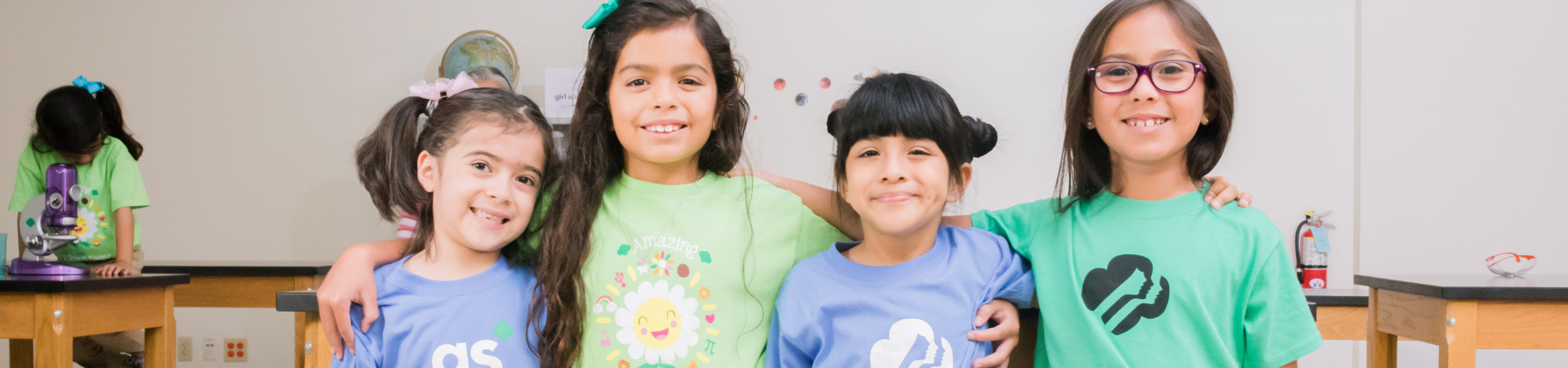  group of girls in girl scout shirts smiling  