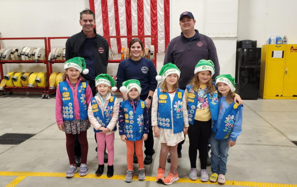 Daisy Girl Scouts stand with FIre Fighters