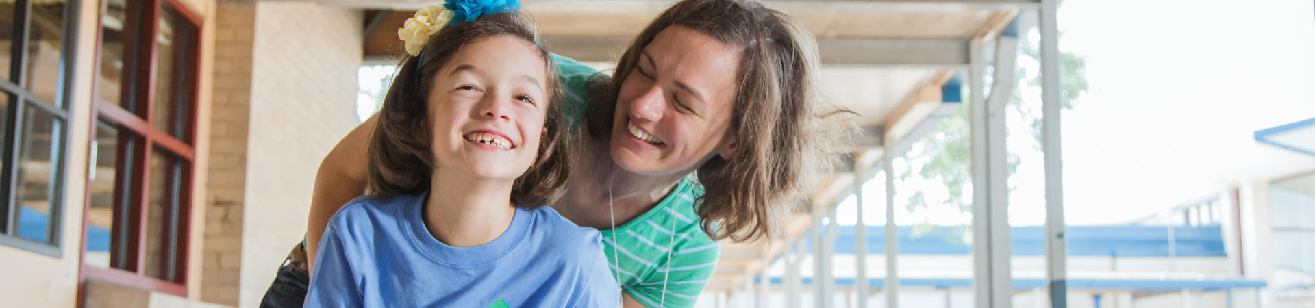  young girl and adult women smiling together at a school 