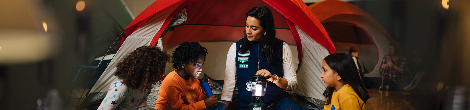  Troop leader with two Girl Scouts smiling outdoors 