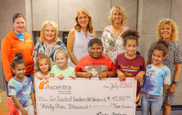 girl scouts stand with donors and girl scout staff after receiving a donation